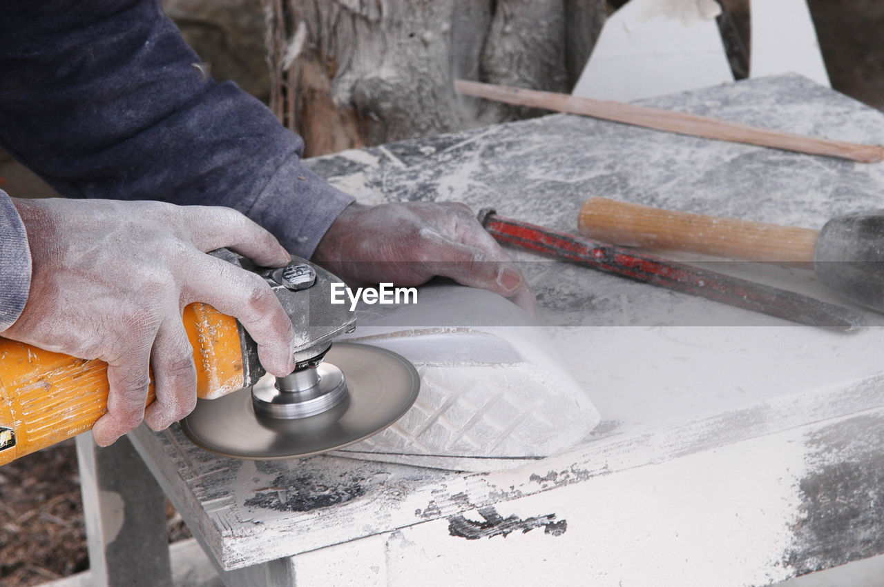 Cropped hand of worker working at construction site