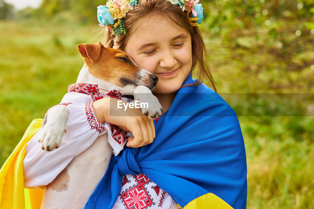 The ukrainian girl hugs her dog.