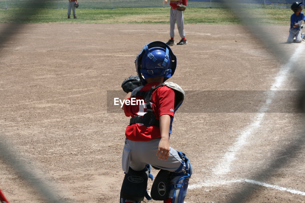 sports, child, baseball, childhood, men, headwear, sports uniform, helmet, group of people, ball game, baseball helmet, sports helmet, clothing, competition, day, full length, sports equipment, baseball uniform, sunlight, standing, footwear, softball, athlete, person, nature, outdoors, sports team, team sport, cooperation, baseball field, playing field