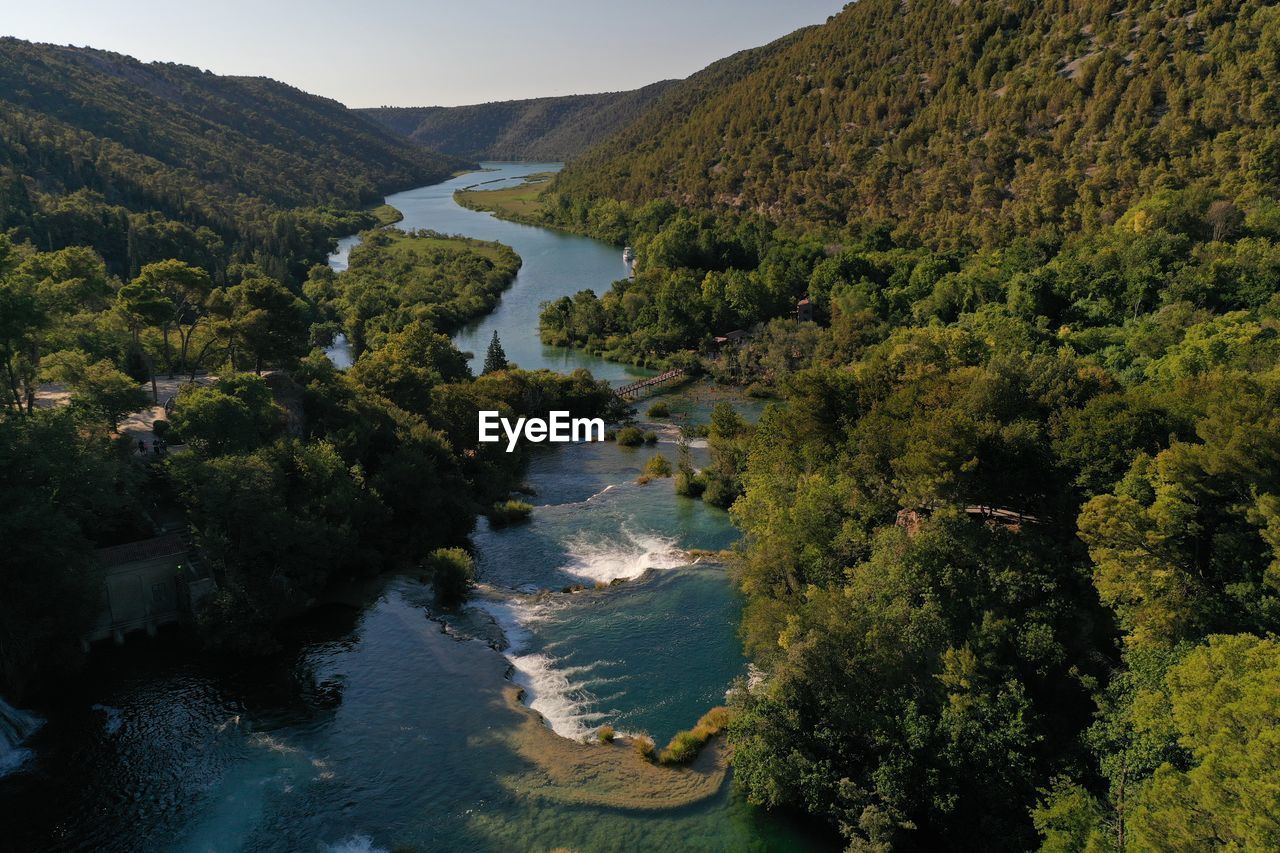 High angle view of river amidst trees against sky