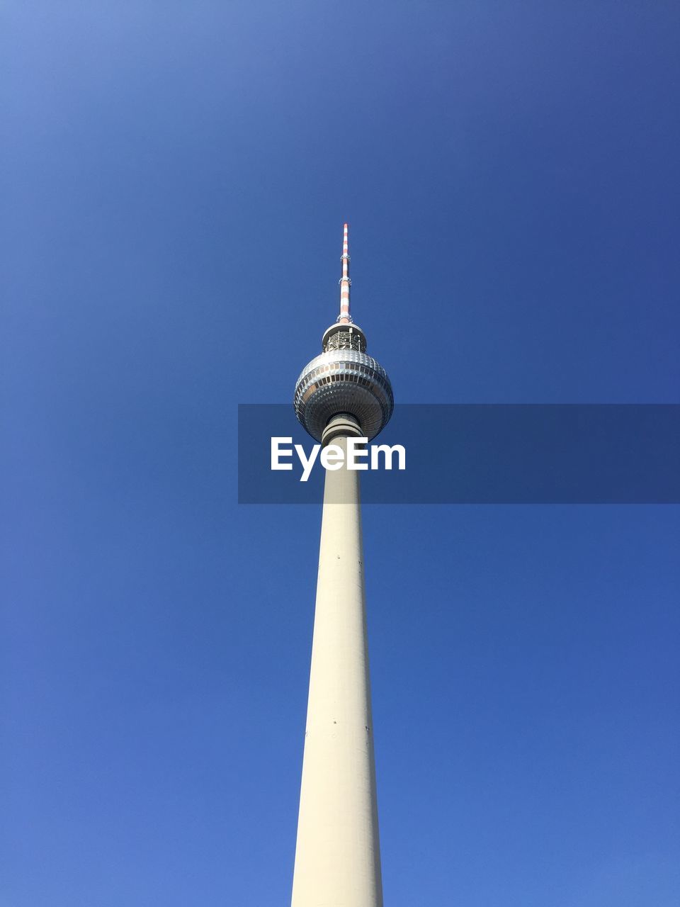 Low angle view of fernsehturm tower against clear blue sky