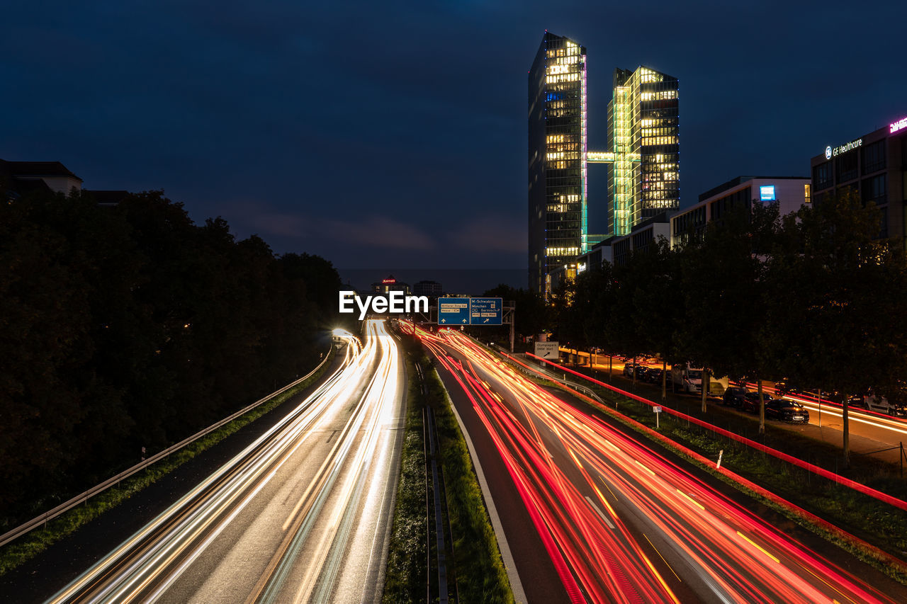 Light trails on road against sky at night