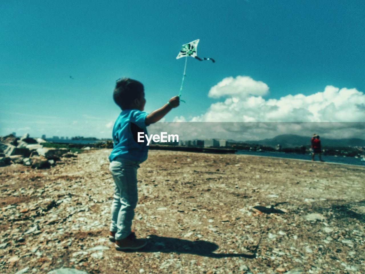 BOY LOOKING AT AIRPLANE ON BEACH