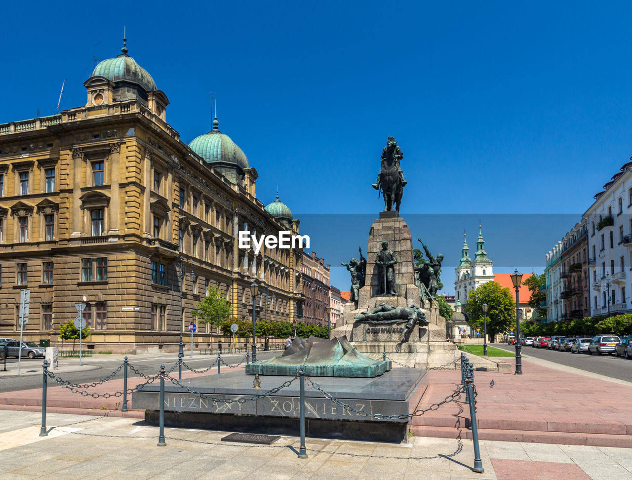 STATUE IN CITY AGAINST BLUE SKY