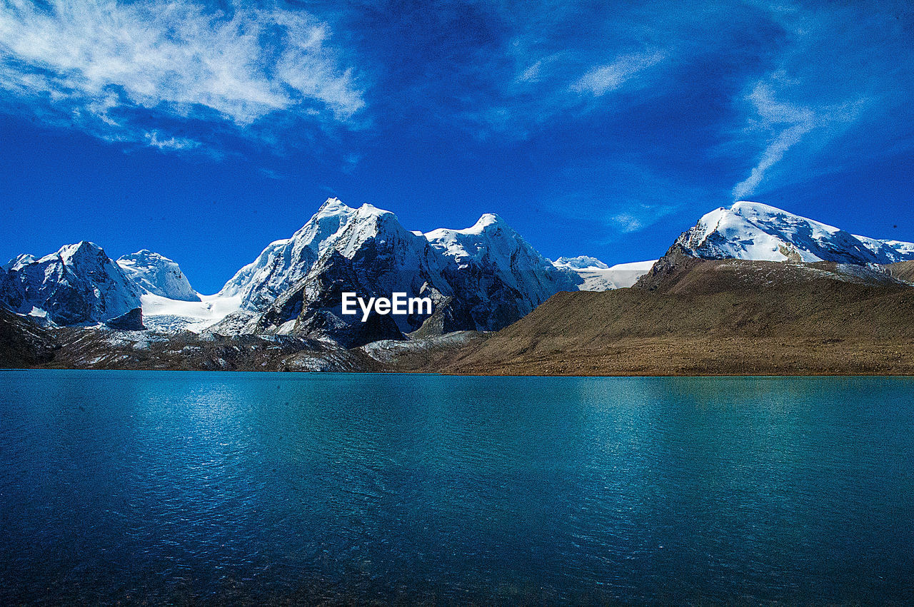 SNOW COVERED MOUNTAINS AGAINST BLUE SKY