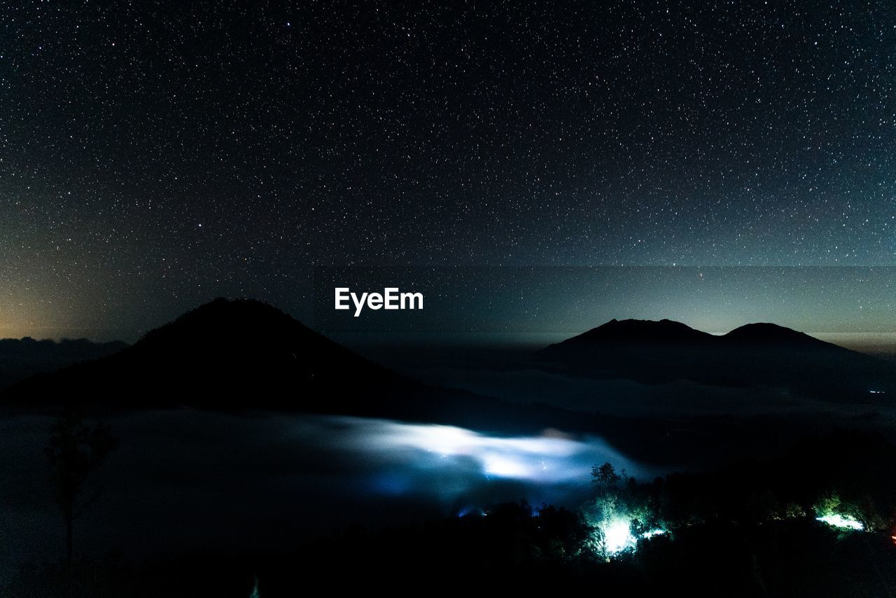 Scenic view of illuminated mountains against sky at night