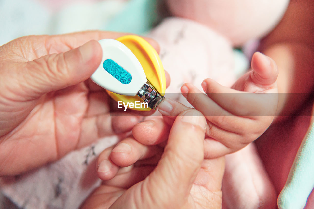 CLOSE-UP OF HAND HOLDING BABY