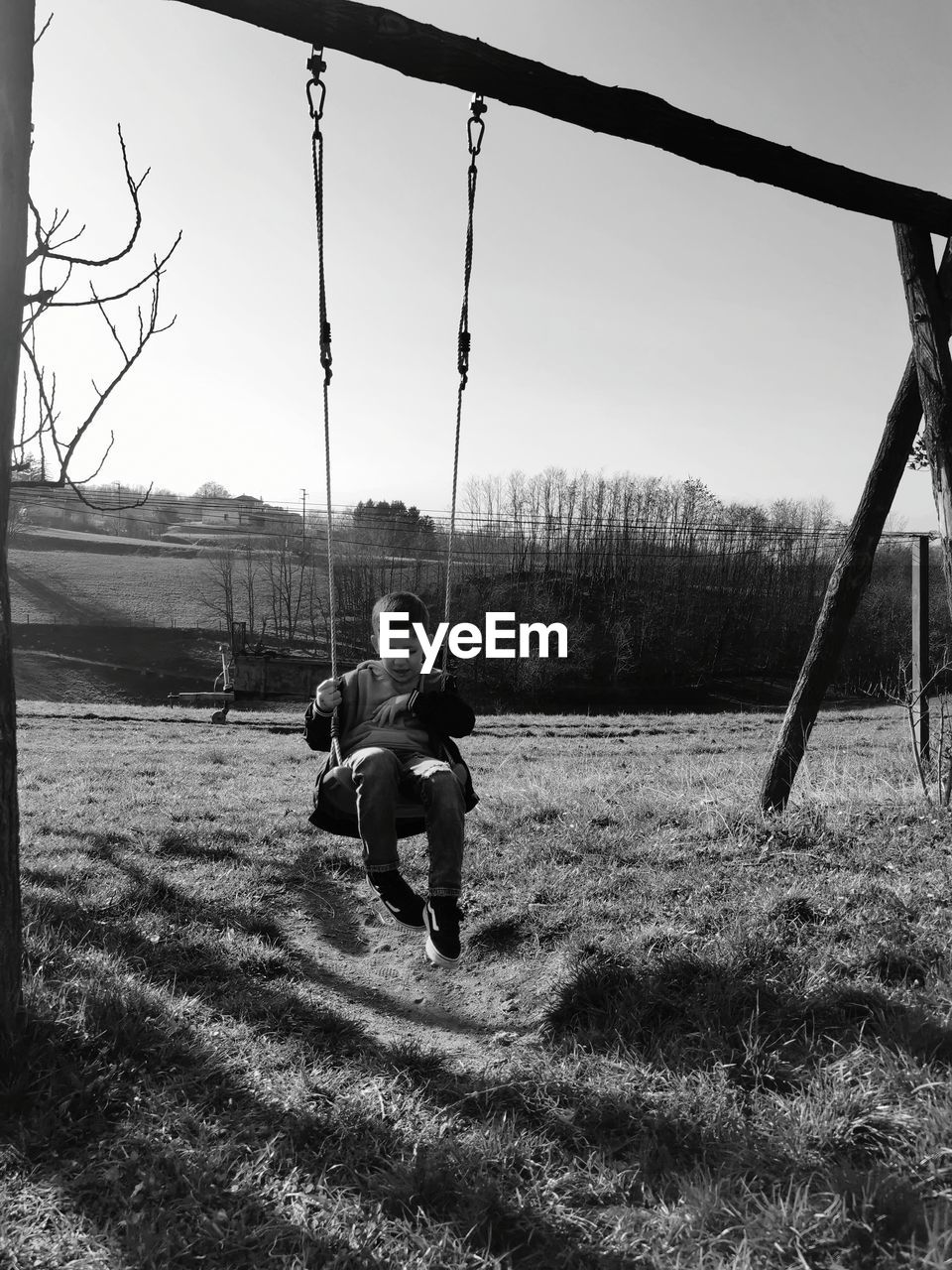 Rear view of boy on swing at playground