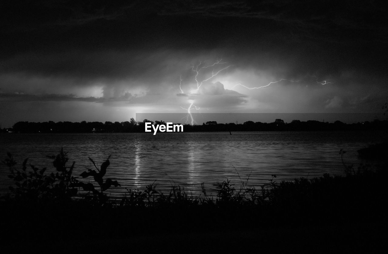 SCENIC VIEW OF LIGHTNING OVER LAKE AGAINST SKY