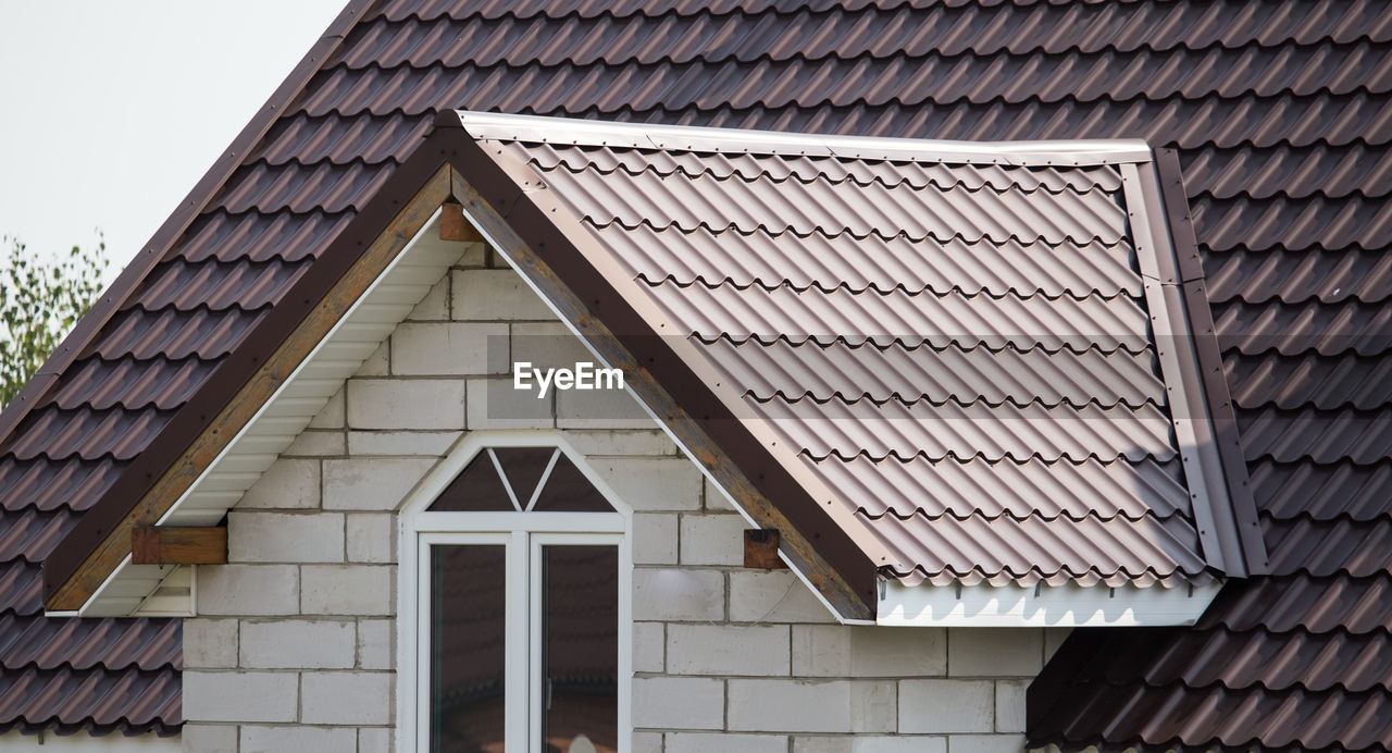 Low angle view of building roof against sky