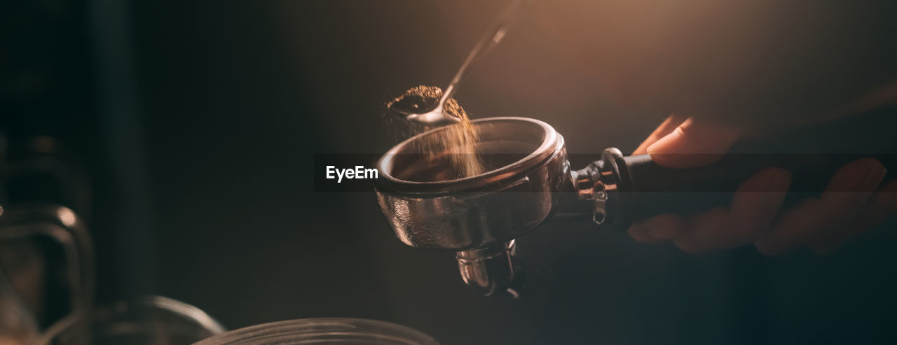 Barista add coffee bean roaster into coffee machine at coffee shop