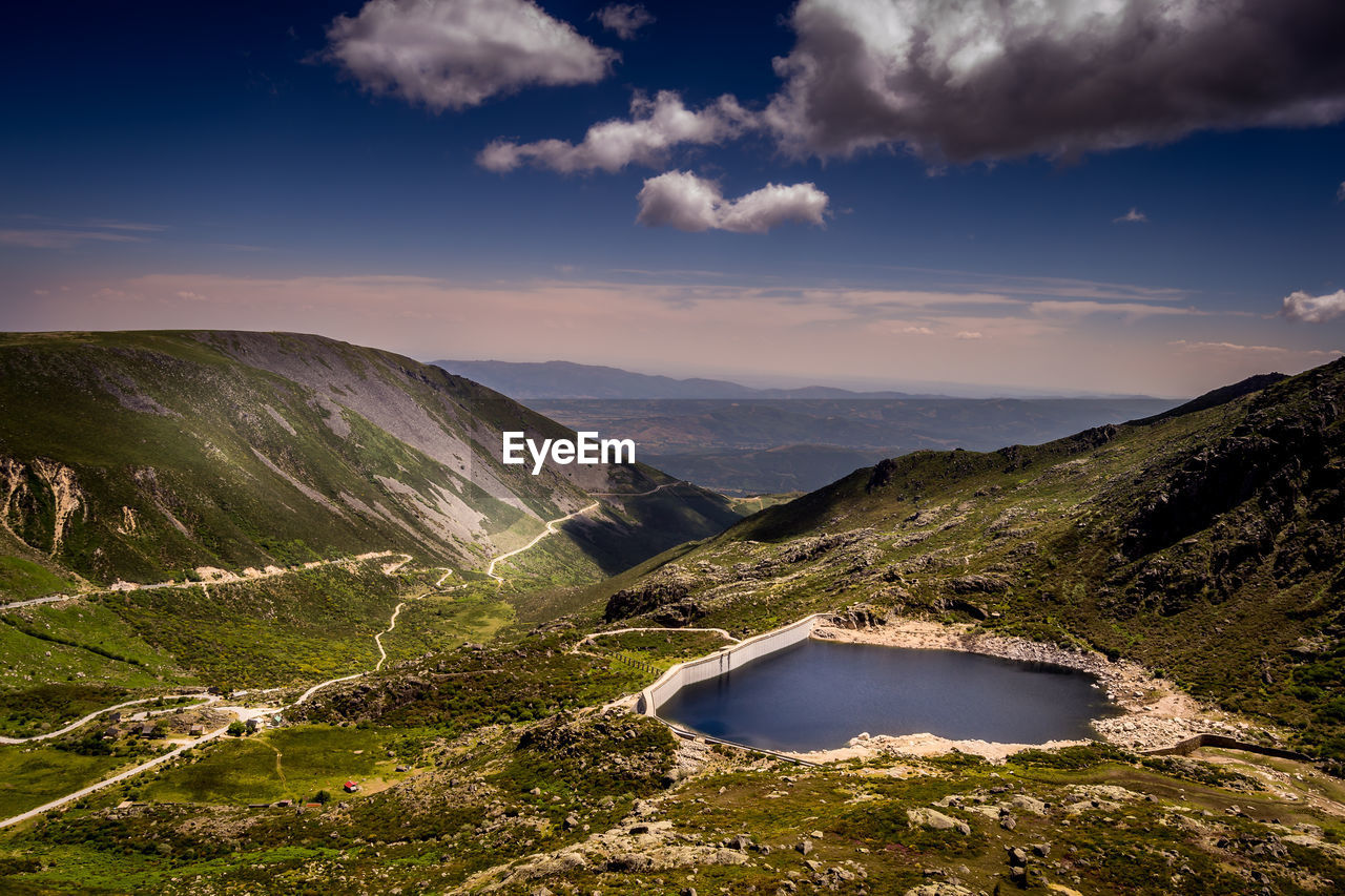 Scenic view of river amidst mountains against sky