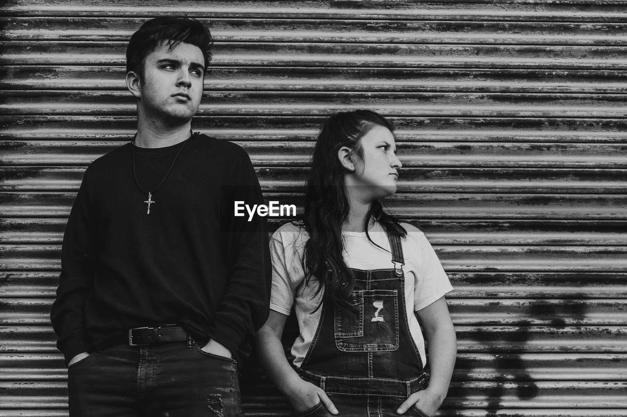 Portrait of  siblings  standing against wall