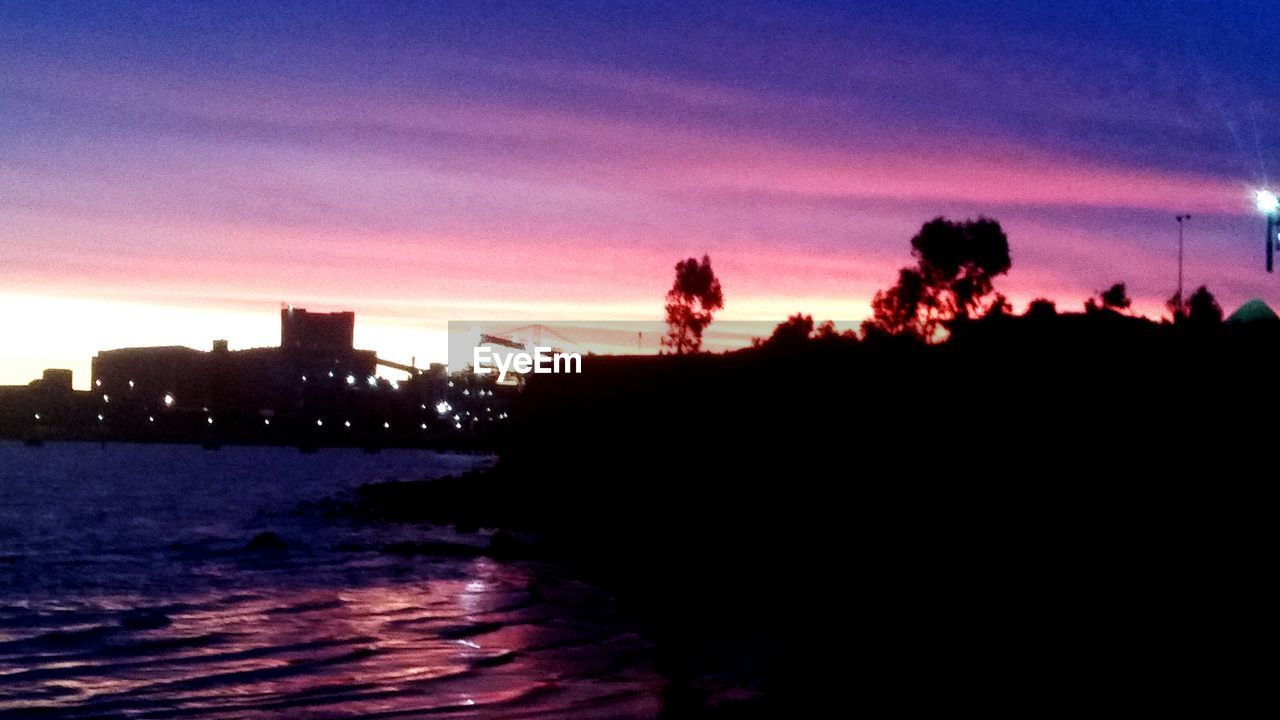 VIEW OF ILLUMINATED CITY AT SUNSET