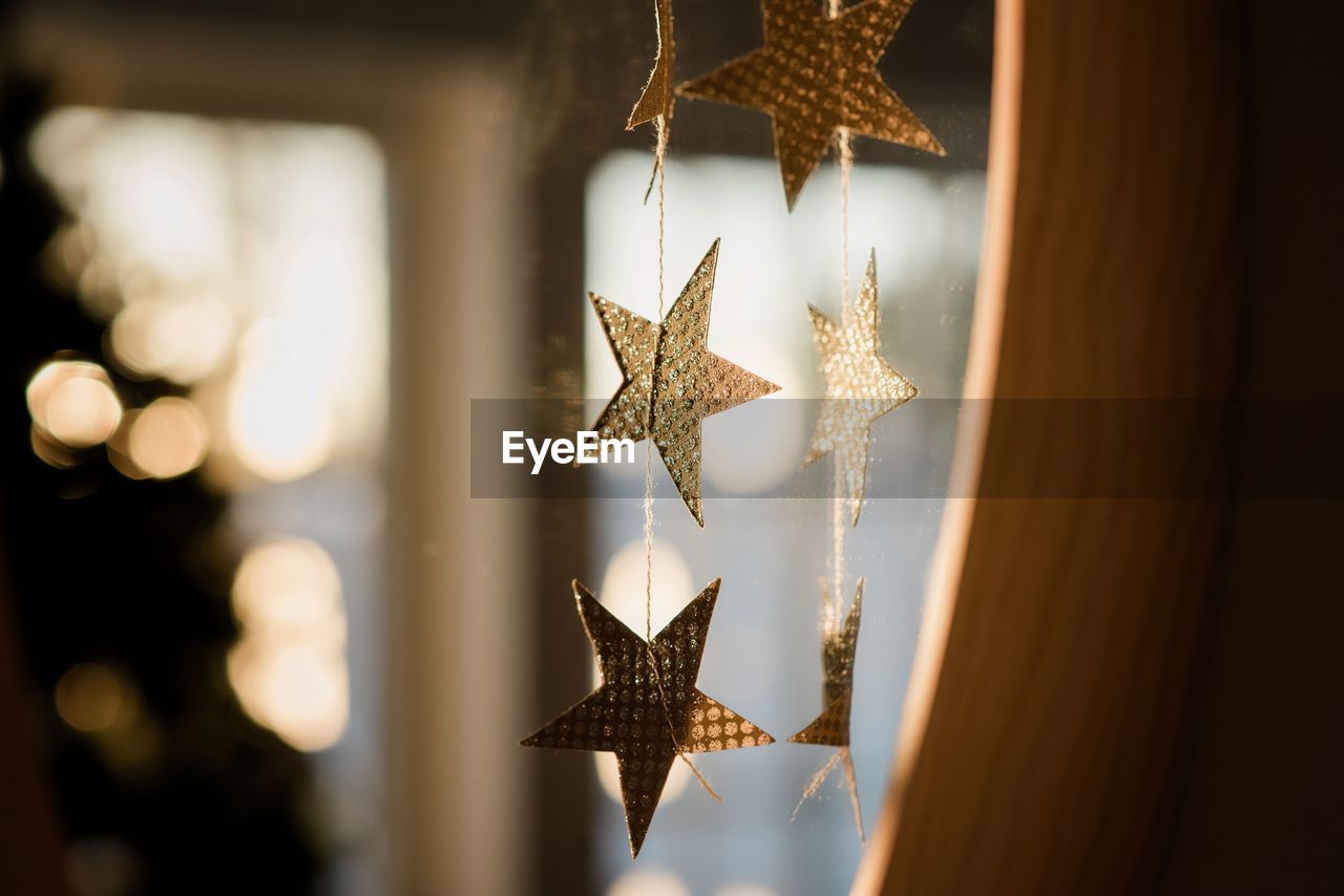 Glittery paper stars decoration sparkling in the sunlight indoors