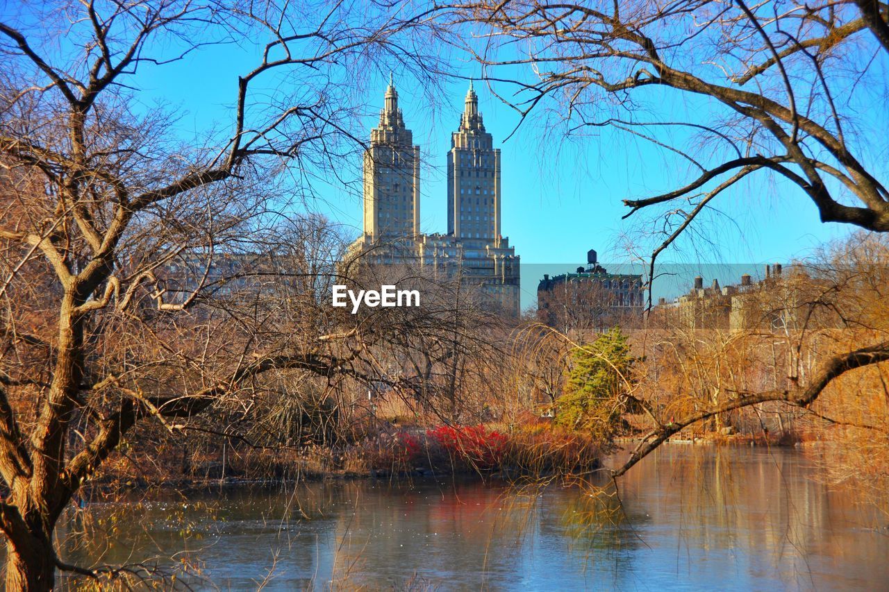 Modern buildings in front of river and trees at central park
