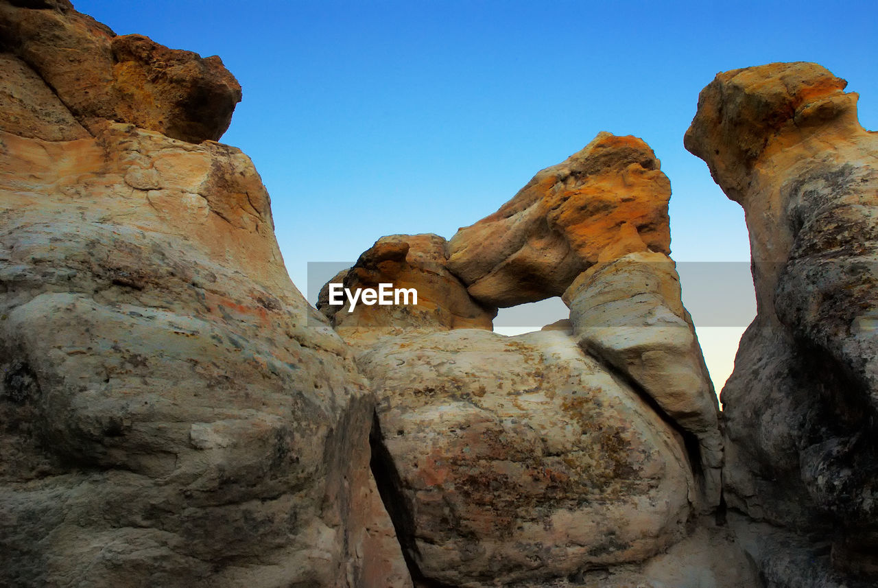 Low angle view of rock formations against blue sky