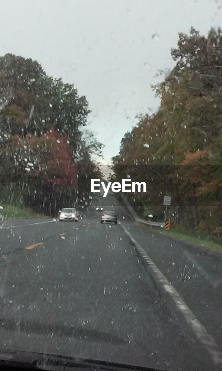 ROAD PASSING THROUGH CAR WINDSHIELD