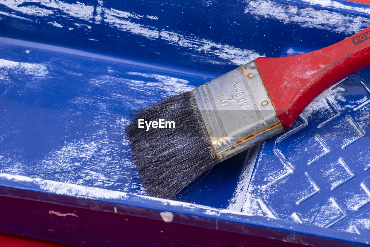 High angle view of paintbrush in blue container