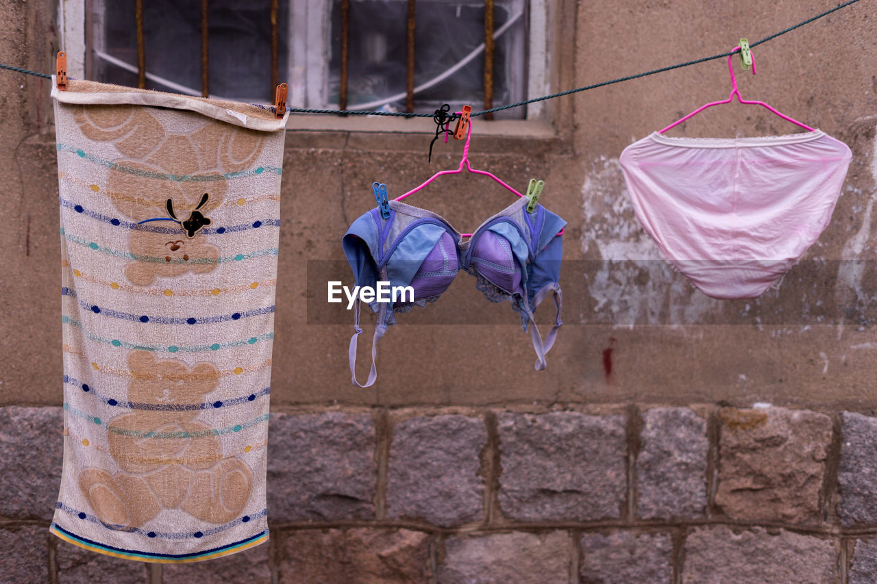 Close-up of clothes drying on clothesline against house