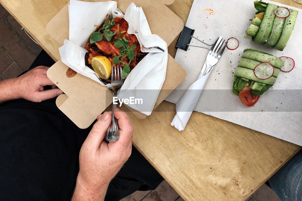 Cropped image of person having lunch at table