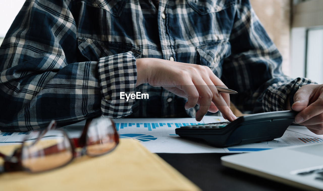 Midsection of man using laptop on table