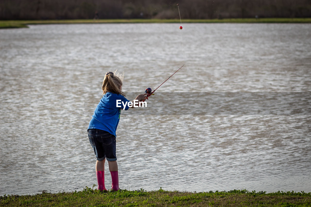 REAR VIEW OF GIRL PLAYING IN WATER