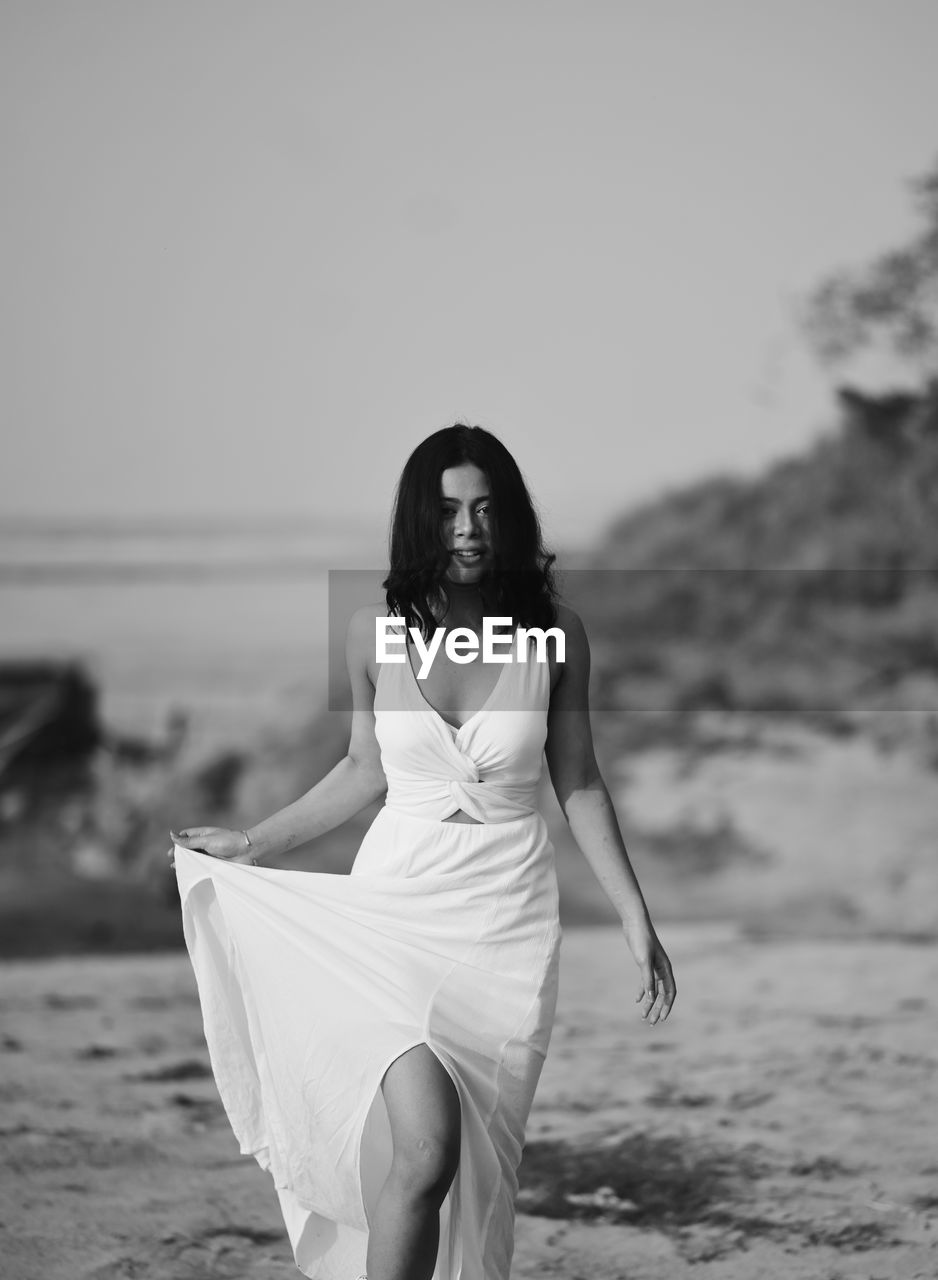 Side view of woman standing at beach