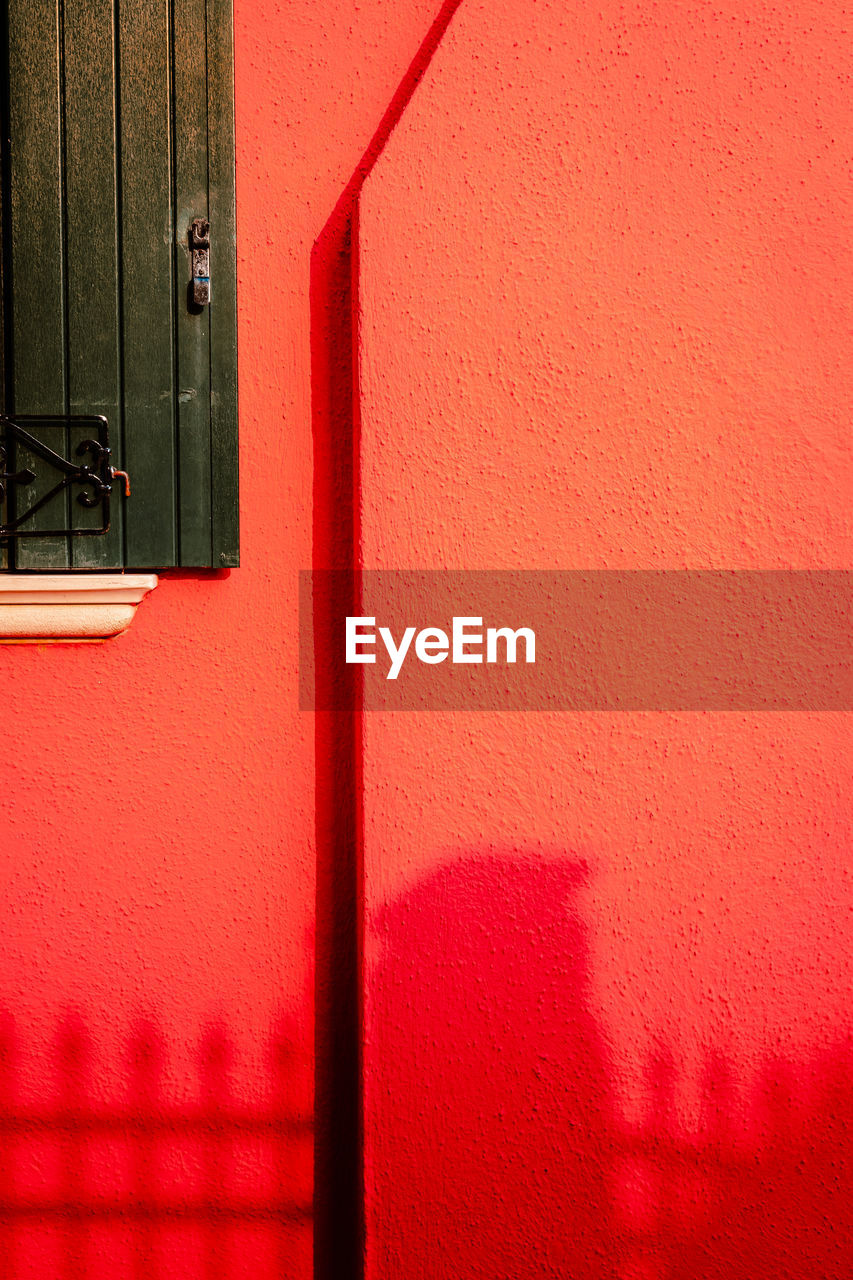 Detail of red colored houses with burano window with shadow