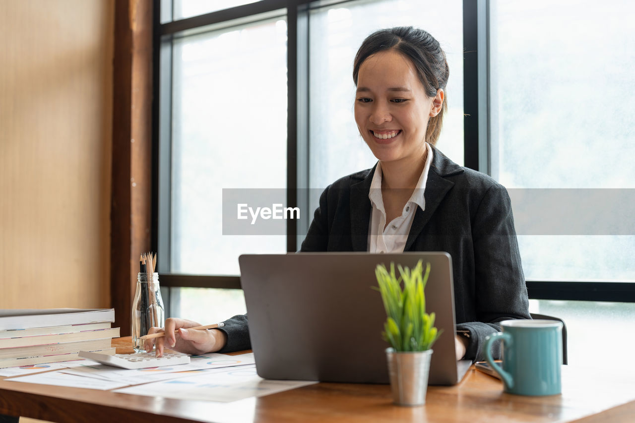 portrait of woman using laptop at table