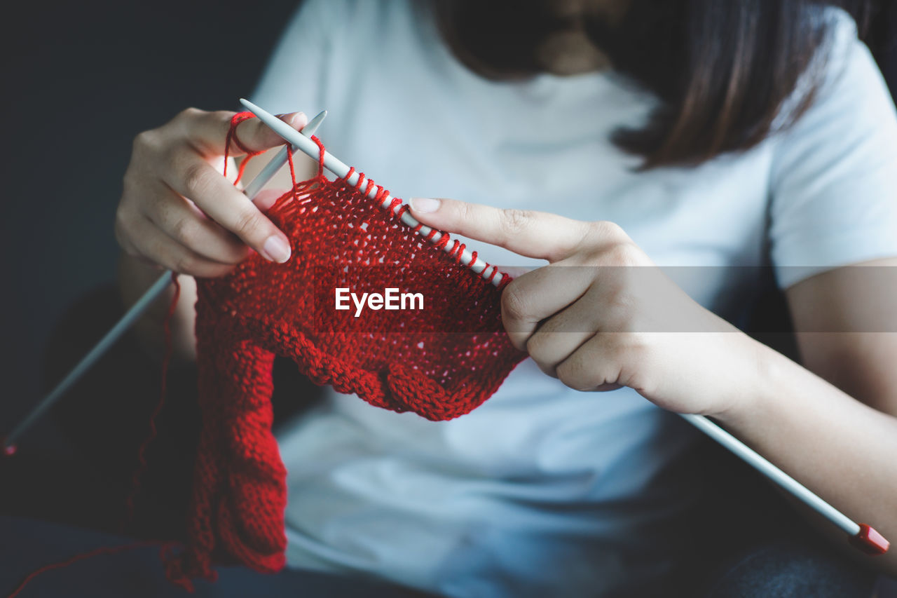 Midsection of woman knitting wool