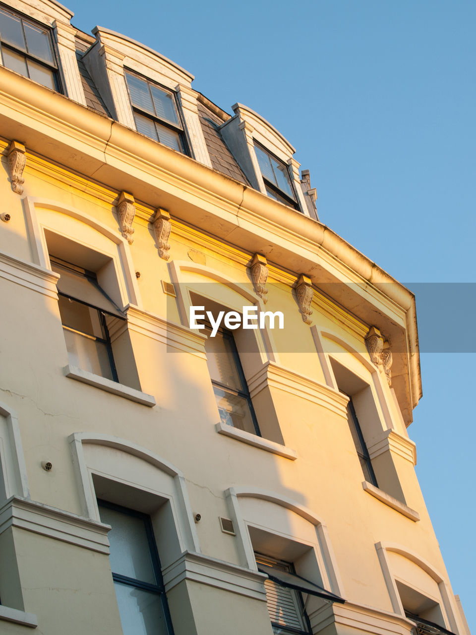 LOW ANGLE VIEW OF APARTMENT BUILDING AGAINST CLEAR SKY