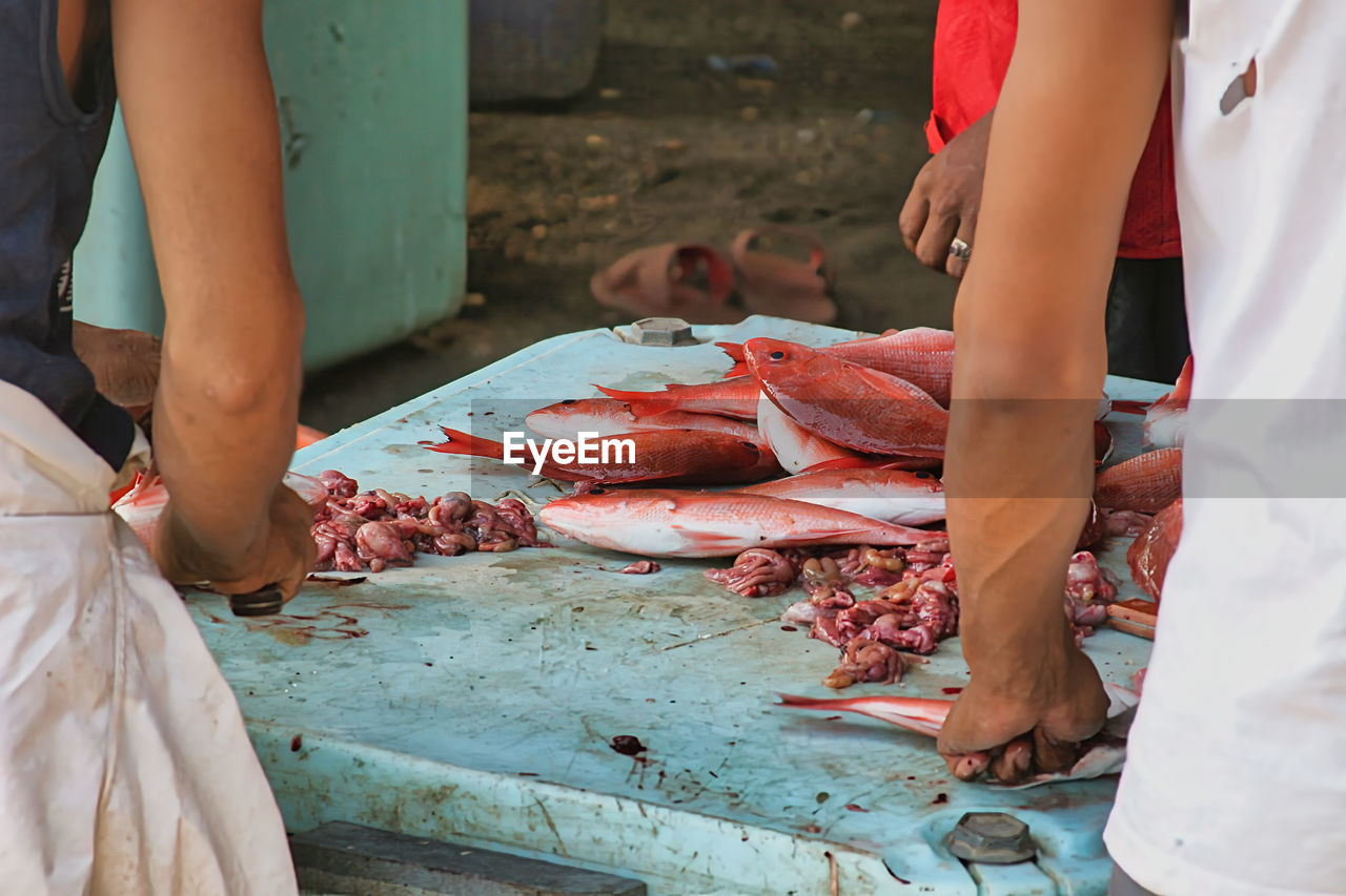 midsection of man preparing seafood on barbecue grill