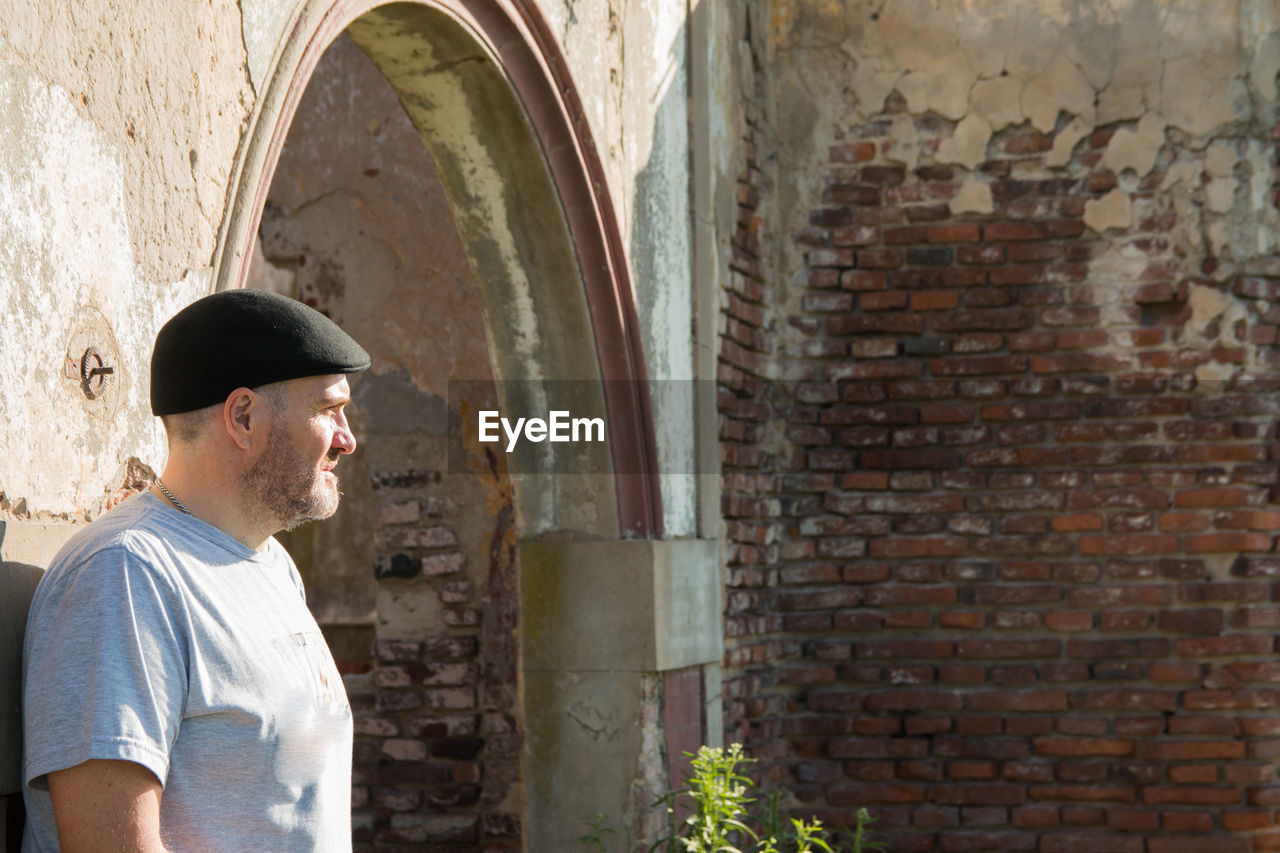 Portrait of man standing against old building