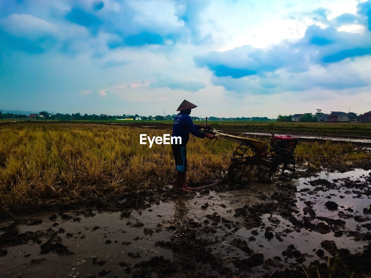 FULL LENGTH OF MAN WORKING ON FIELD