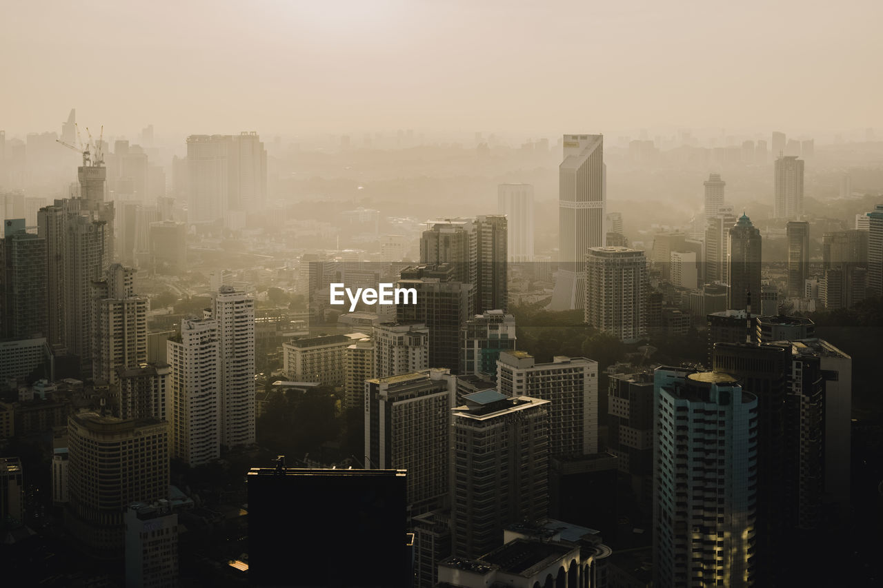 Aerial view of buildings in city against sky