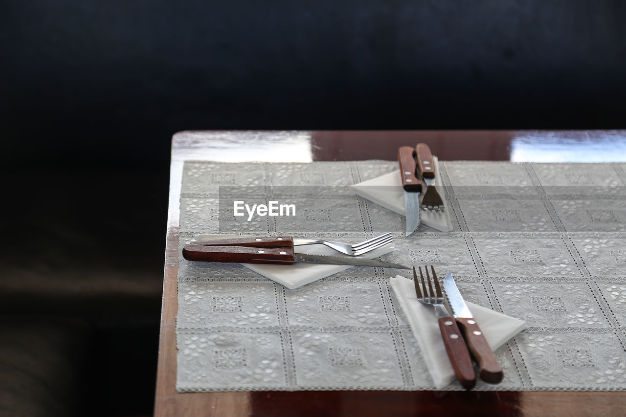 High angle view of cutlery and napkins on dining table