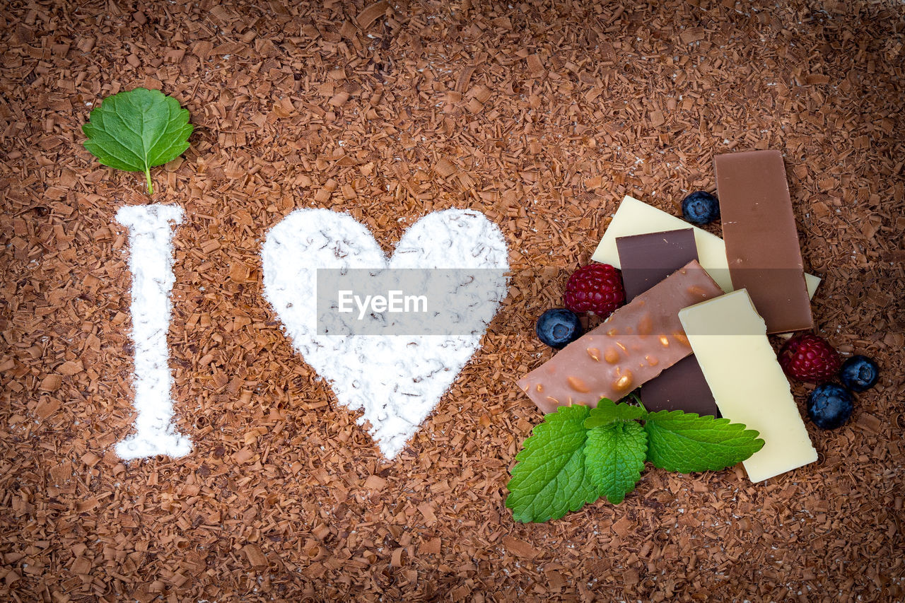 Directly above shot of letter i and heart shape with chocolates