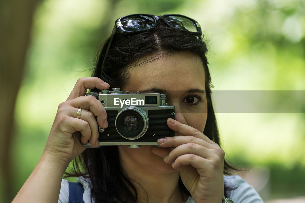 Portrait of woman photographing outdoors