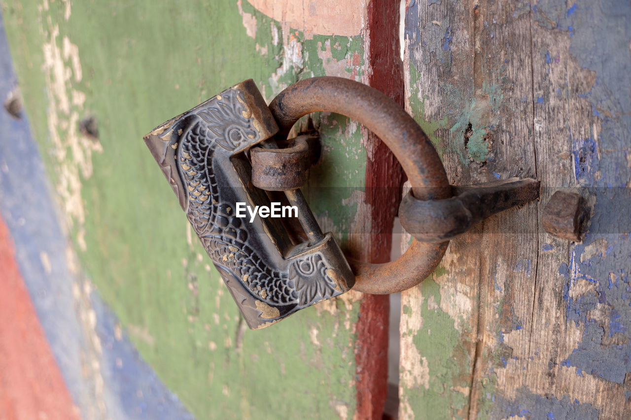 CLOSE-UP OF OLD RUSTY METAL DOOR WITH HANDLE