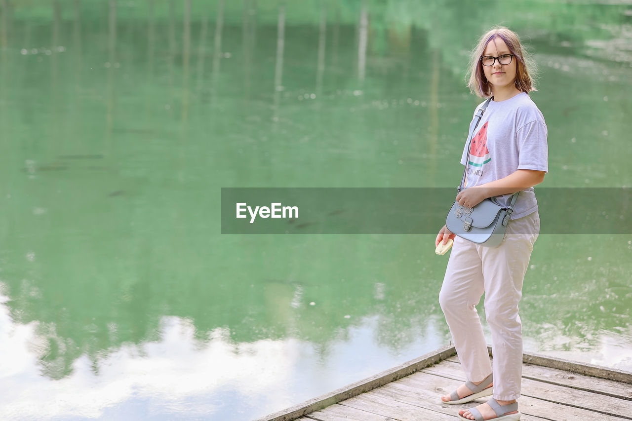 A girl on the shore of the lake with fish on a summer day