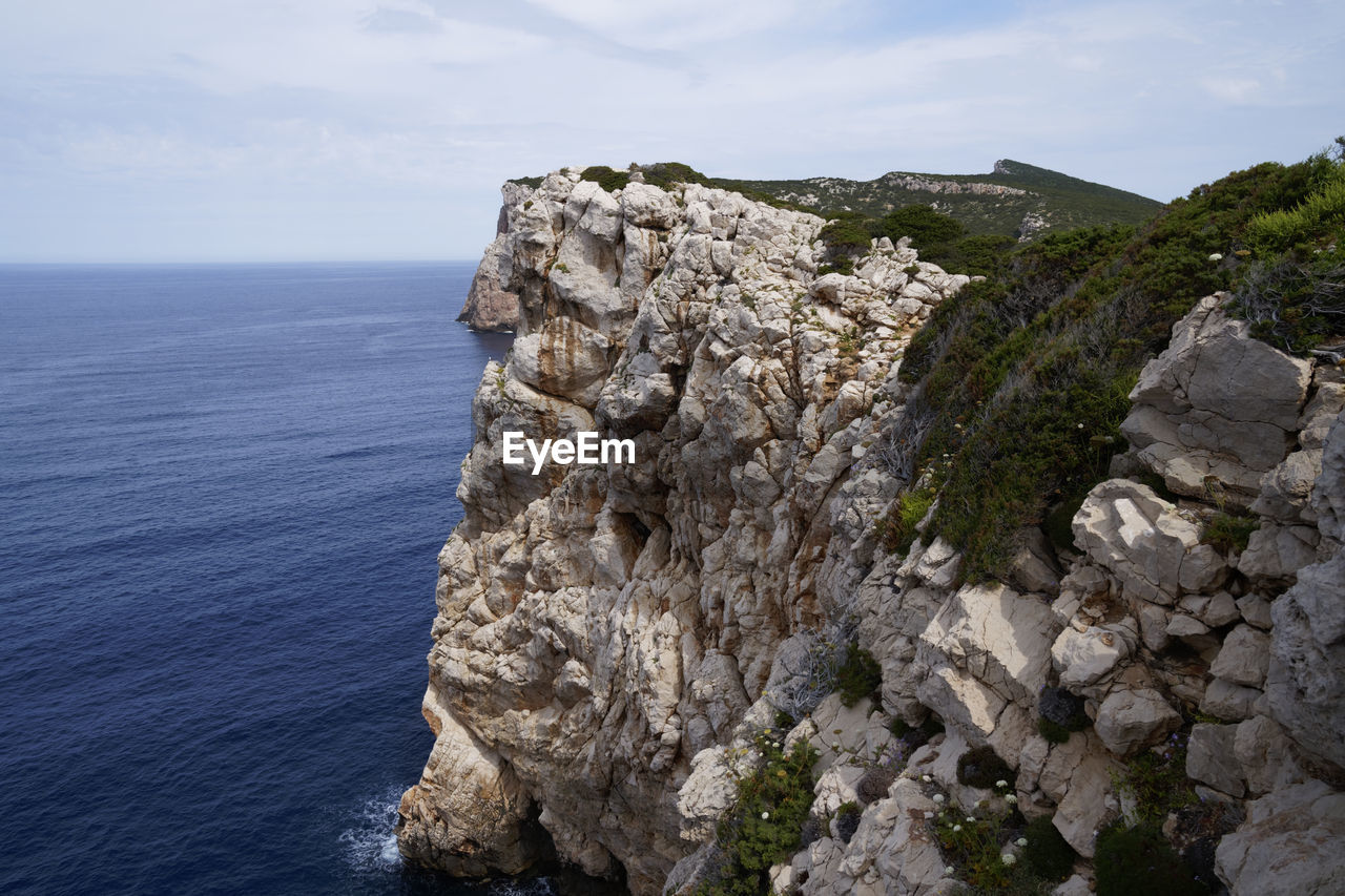 Rock formations by sea against sky