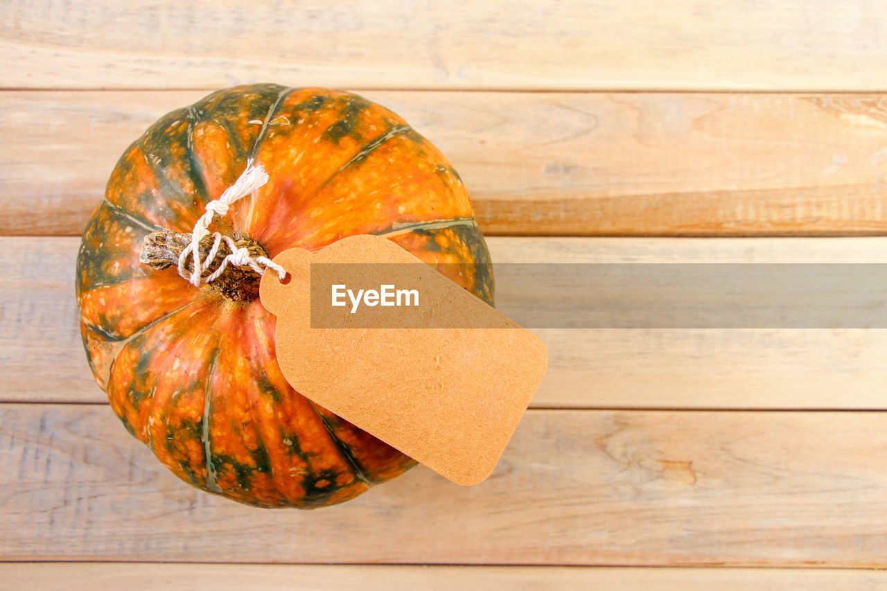 wood, food and drink, food, produce, orange color, yellow, pumpkin, healthy eating, autumn, no people, indoors, freshness, table, still life, wellbeing, leaf, high angle view, directly above, studio shot, vegetable, close-up, single object, nature, fruit, copy space