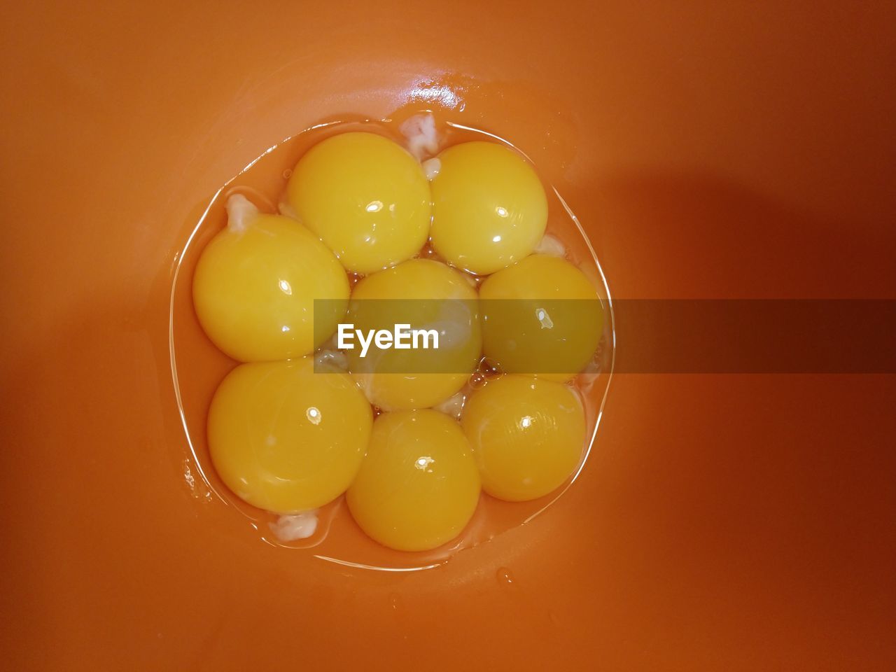 HIGH ANGLE VIEW OF YELLOW EGGS IN PLATE