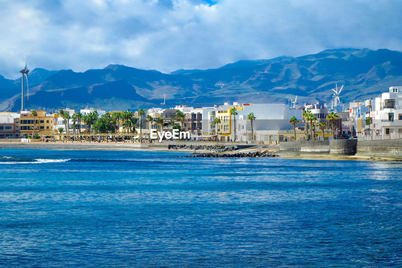 Scenic view of sea and buildings against sky