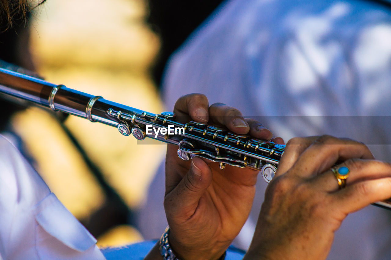 musical instrument, music, arts culture and entertainment, musician, hand, western concert flute, performance, flute, adult, skill, close-up, blue, musical equipment, woodwind instrument, one person, holding, wind instrument, focus on foreground, performing arts event
