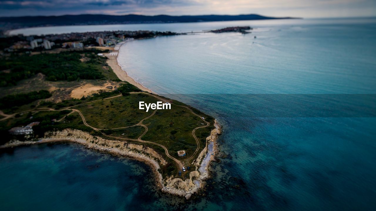 Aerial view of city by sea against sky