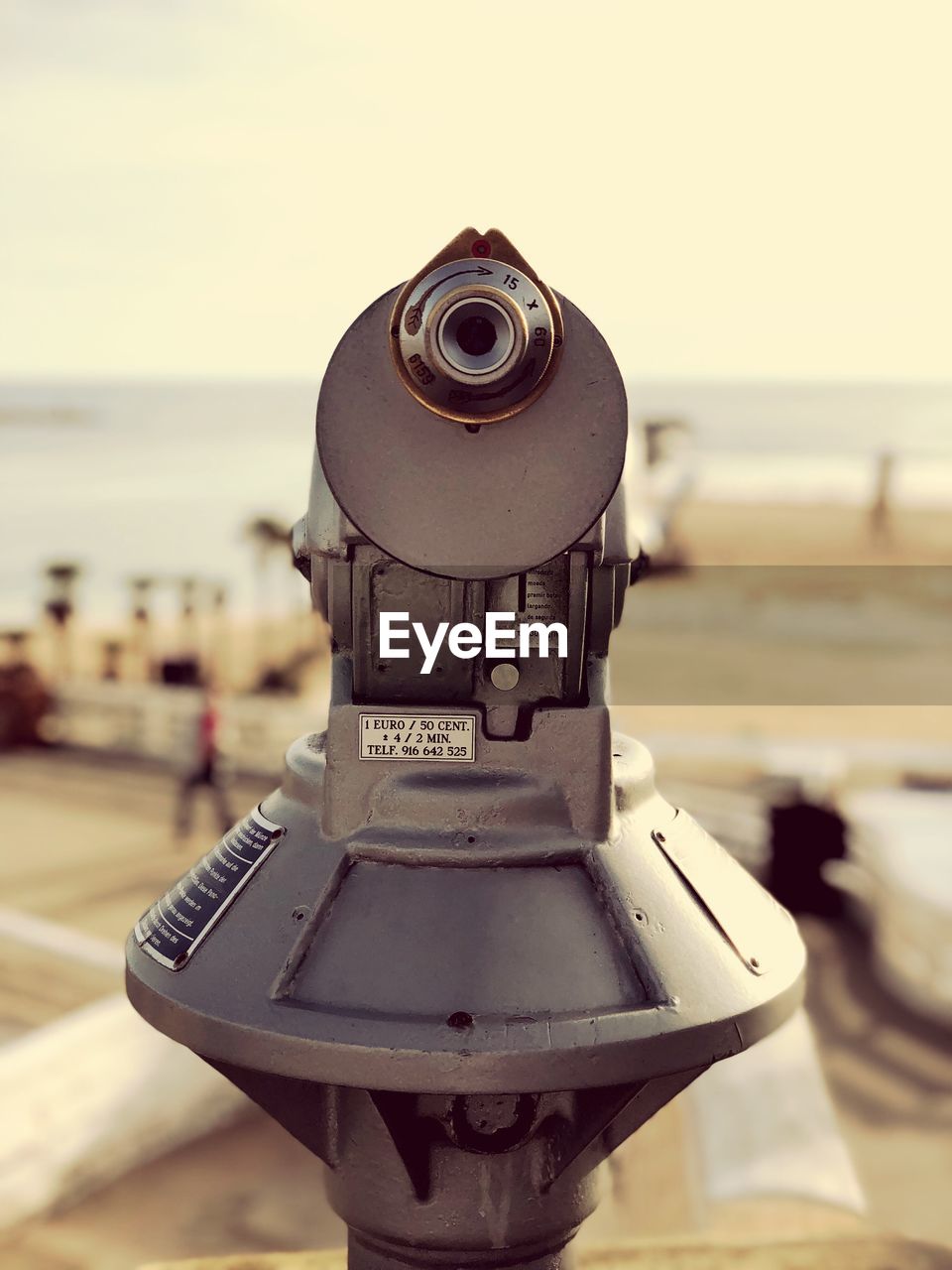 CLOSE-UP OF COIN-OPERATED BINOCULARS AGAINST SEA AGAINST SKY