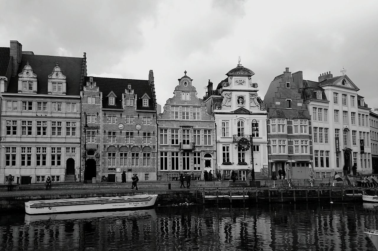 Buildings in city against cloudy sky