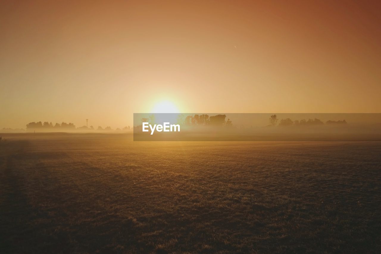 Scenic view of field against sky during sunset